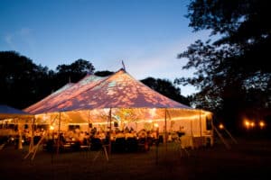 Wedding tent at night Special event tent lit up from the inside with dark blue night time sky and trees