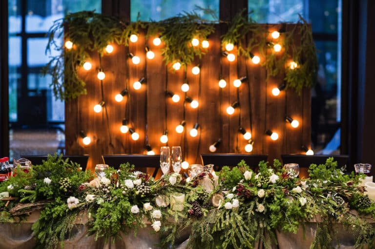 Wedding table decorated with garland of vintage lamps